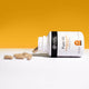 Canine Ceuticals Pure SB supplement lies on its side with several tan capsules spilled out.
